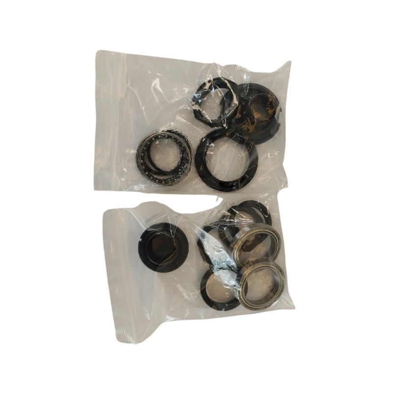 Two clear plastic bags containing black metal washers on a white background