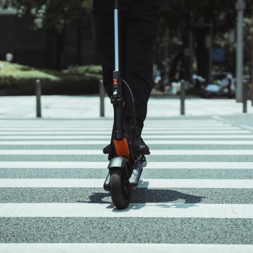 Person riding an Apollo Explore 2.0 electric scooter on a crosswalk