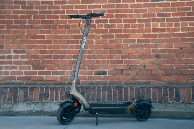 Apollo City 2022 e-scooter standing outside in front of brick wall